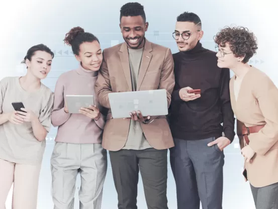 Group of people on a techno background looking at a laptop